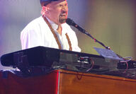 Felix Cavaliere singing and playing the keyboard in concert.
